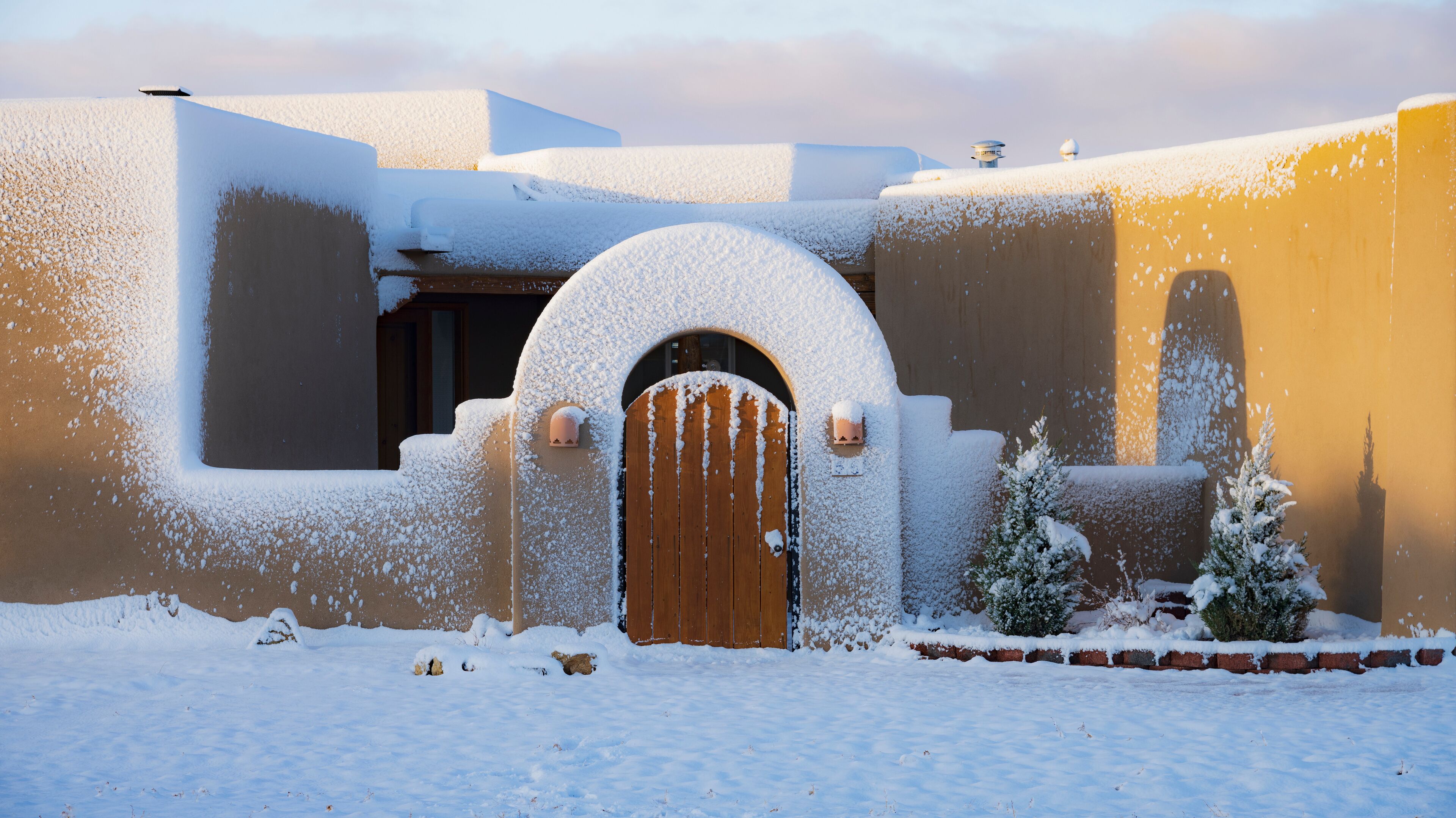 Usa, New Mexico, Santa Fe, Adobe style house covered with snow in winter