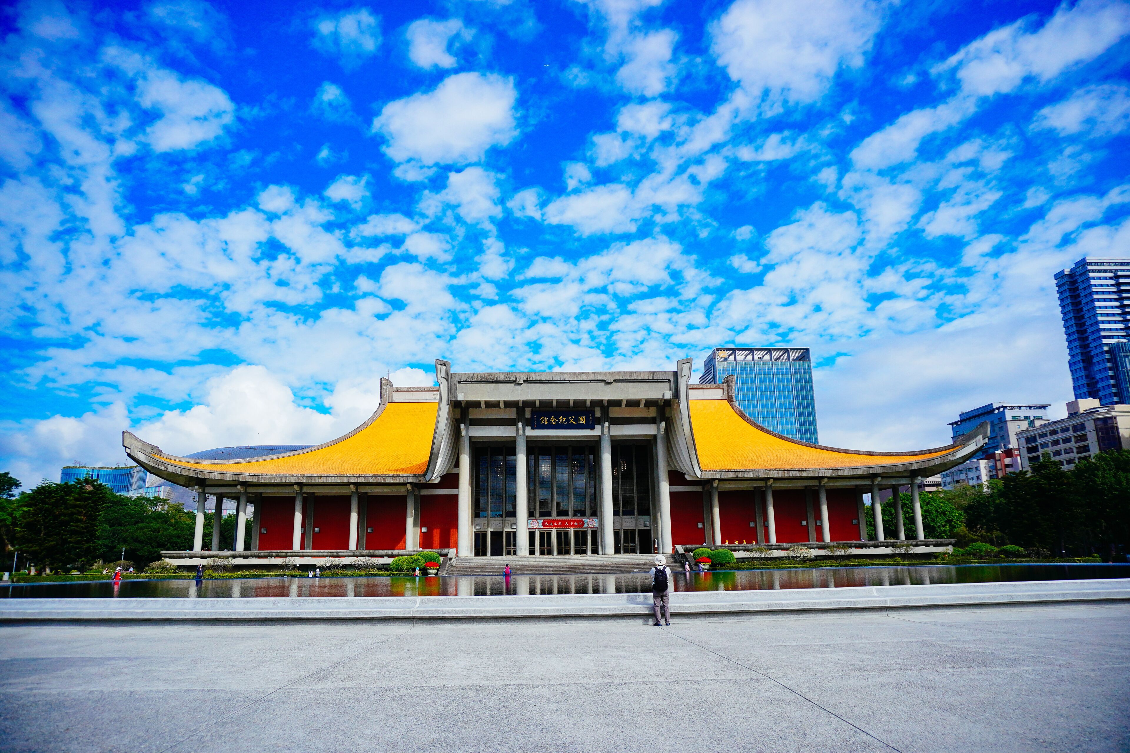 A traditional building with yellow roofs and a large open plaza in front.