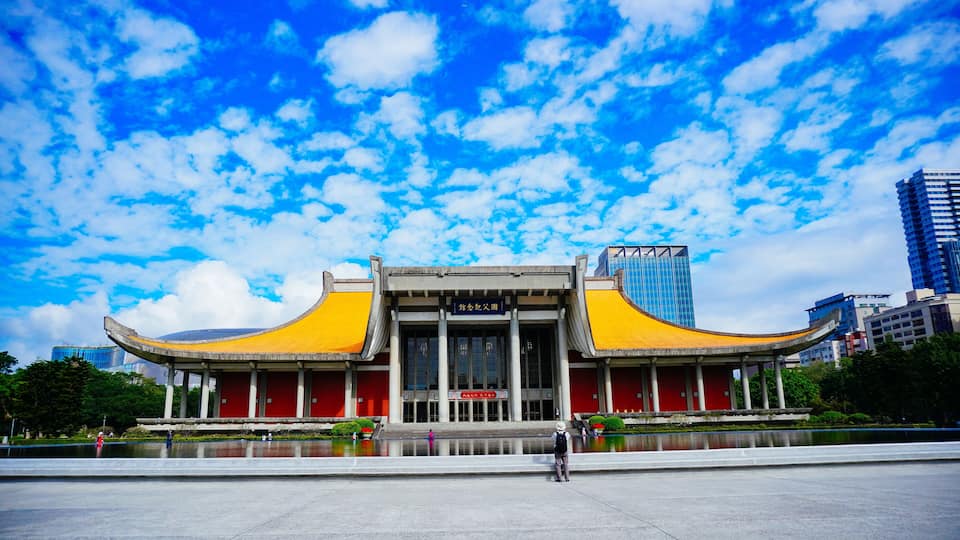 A traditional building with yellow roofs and a large open plaza in front.