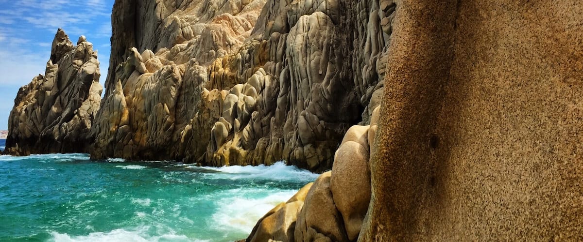 Lovers Beach. It's a sandy area between the cliffs that you take a boat ride to get to