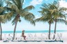 A beach with palm trees and the word "ISLAND" in the sand.