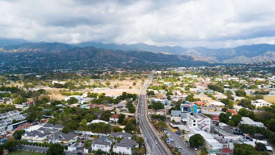 A cityscape with a prominent road leading towards mountains.