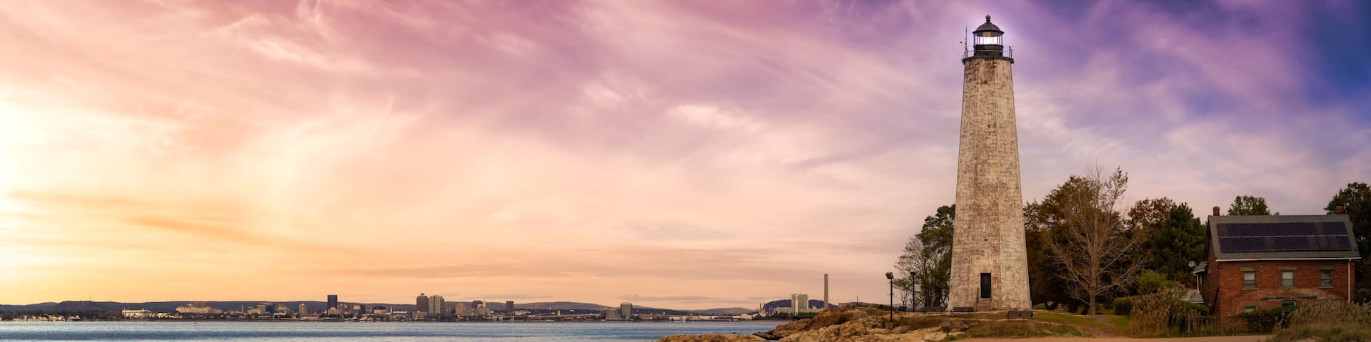 Panoramic view on a lighthouse on the Atlantic Ocean Coast. Colorful Sunrise Sky Art Render. Taken in Lighthouse Point Park, New Haven, Connecticut, United States.
