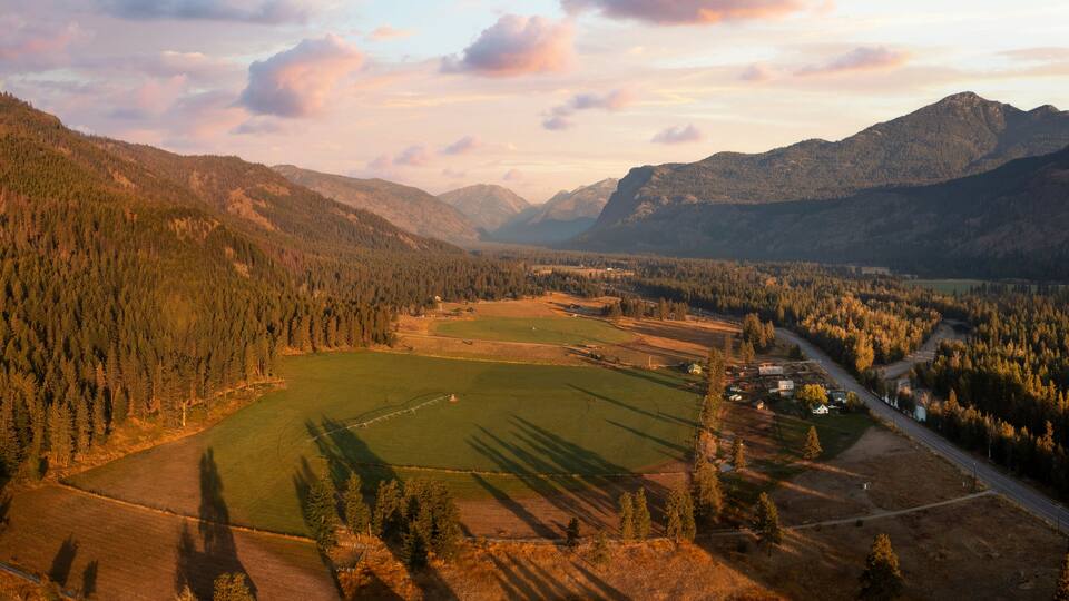 Aerial Panoramic View of the Historic Methow Valley in Eastern Washington State. Farm and ranch land lead to the North Cascade Mountains in this stunning landscape photographed on an autumnal morning.