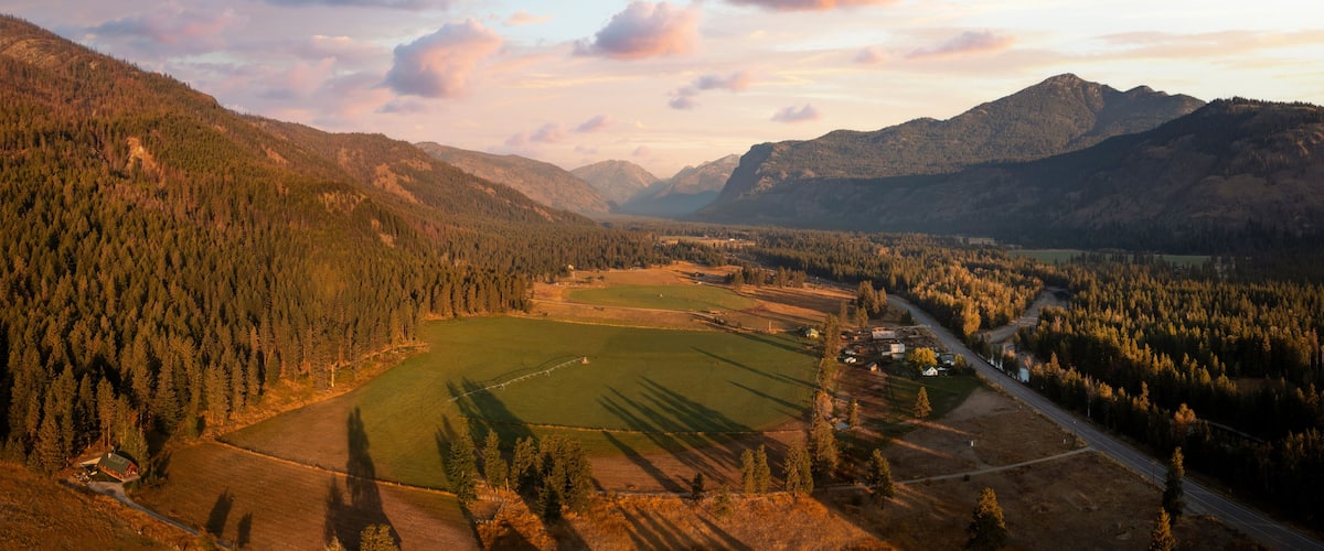 Aerial Panoramic View of the Historic Methow Valley in Eastern Washington State. Farm and ranch land lead to the North Cascade Mountains in this stunning landscape photographed on an autumnal morning.