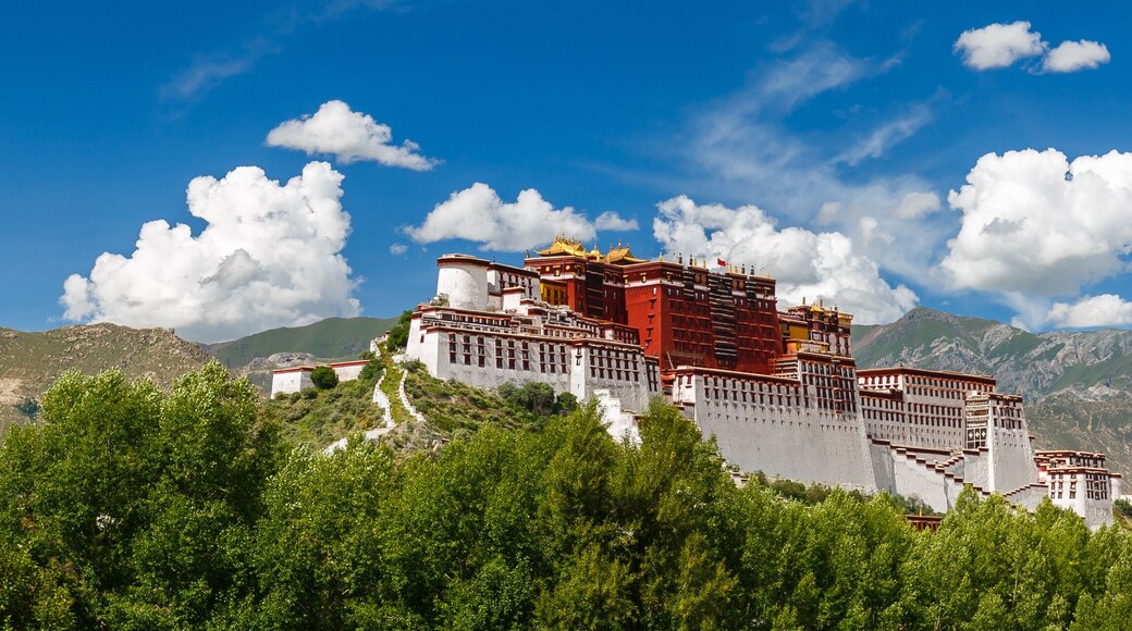 LHASA, TIBET / CHINA - July 31, 2017: Panorama of Potala Palace - home of the Dalai Lama and Unesco World Heritage. Blue sky, clouds. Amazing view of the ancient fortress. Center of Tibetan Buddhism.