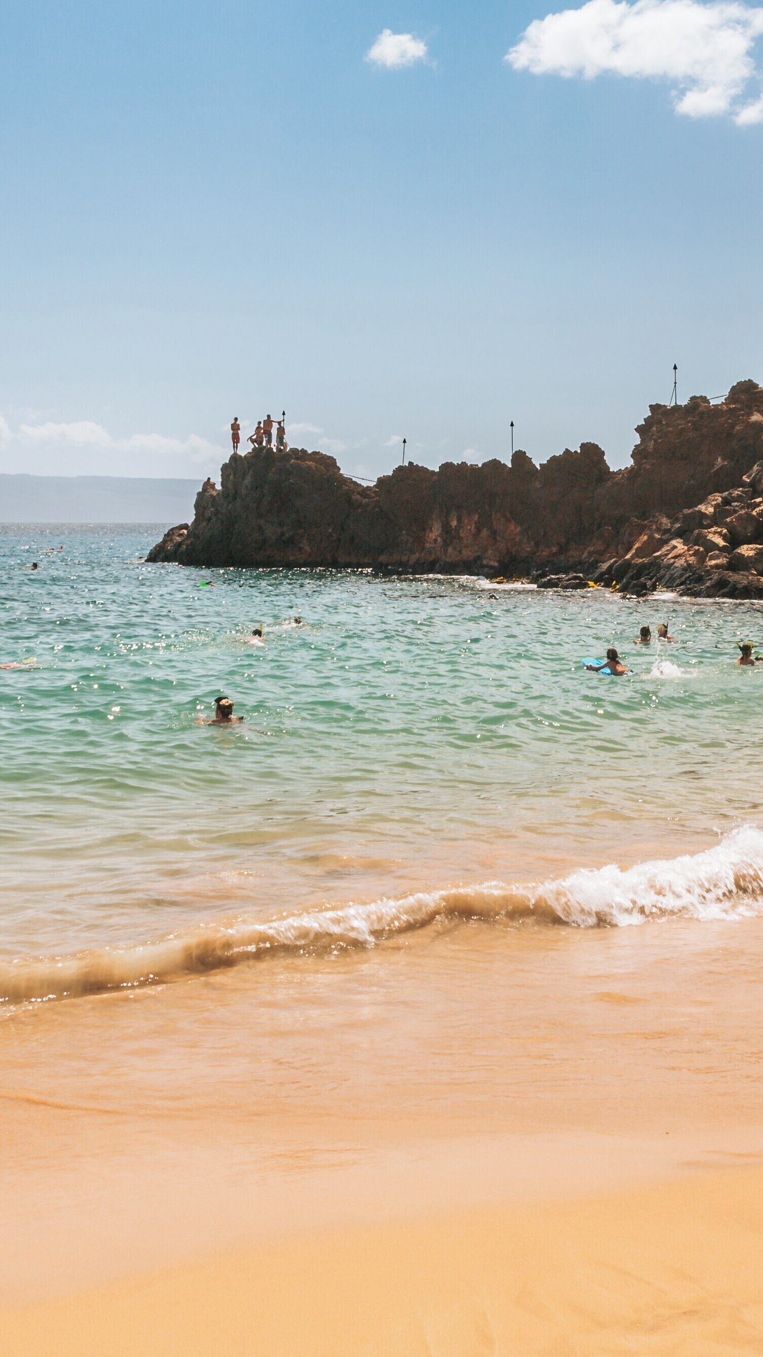 Kaanapali Beach offers a perfect combination of swimming, sunbathing, and cliff jumping in Lahaina, Hawaii during a sunny day