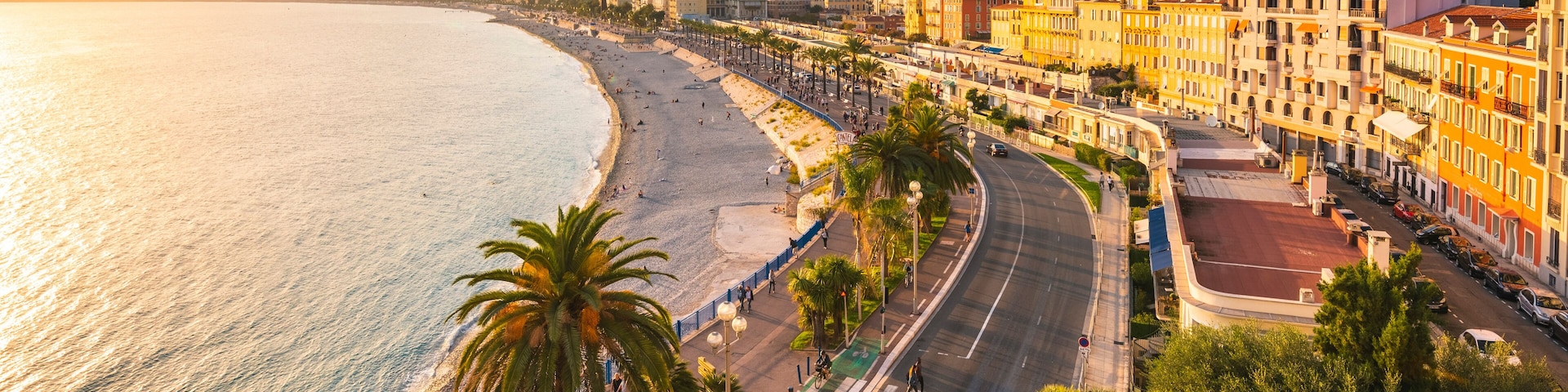 A coastal cityscape with a beach, palm trees, and colorful buildings along the waterfront.