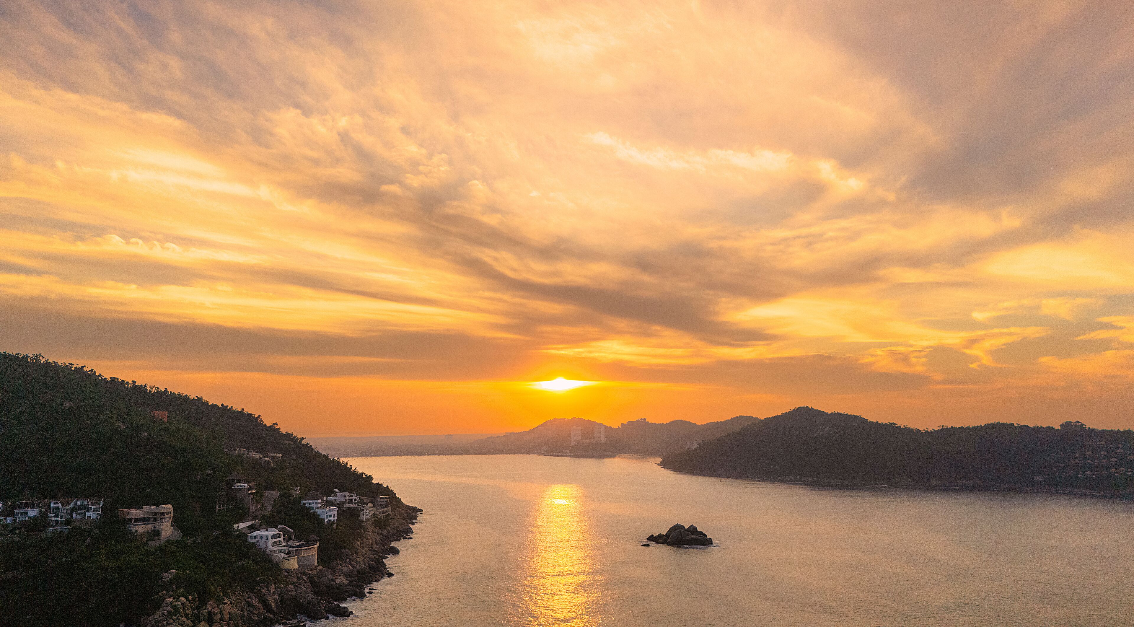 Beautiful sunrise at the entrance of the bay of Puerto Marques in Acapulco. The sun rises over the horizon announcing the arrival of a new day in this Mexican tourist destination.