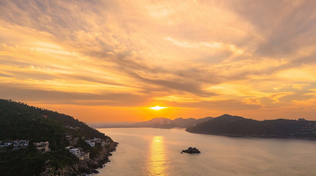 Beautiful sunrise at the entrance of the bay of Puerto Marques in Acapulco. The sun rises over the horizon announcing the arrival of a new day in this Mexican tourist destination.