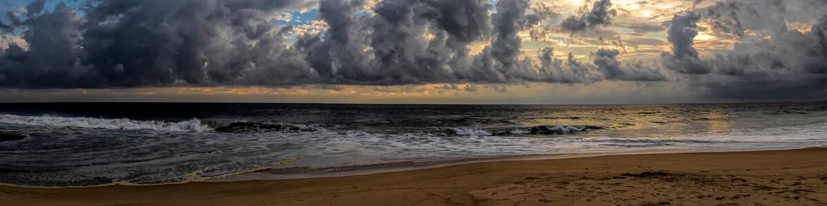 seascape of storm clouds at sunset over the sandy beach at Pie de la Cuesta in Acapulco, Mexico with dramatic light