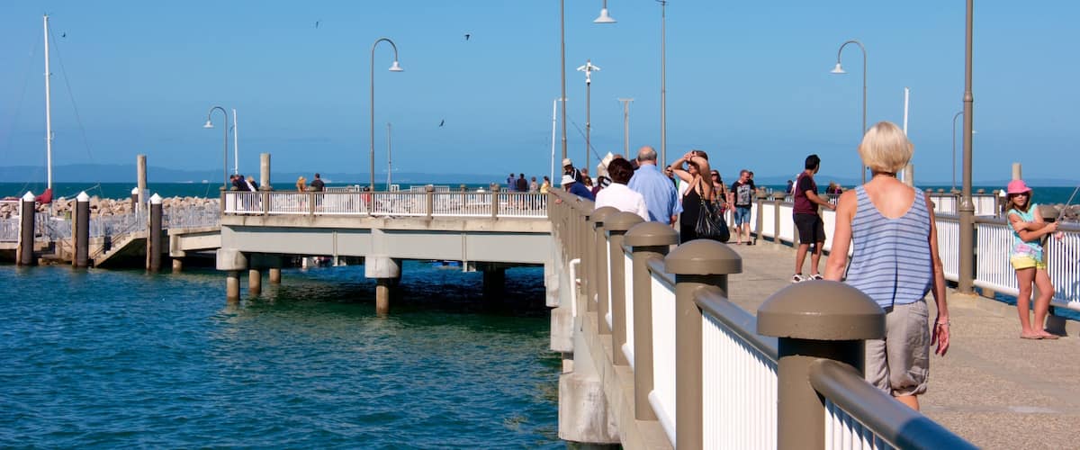 Un muelle con gente caminando, con vistas al agua.