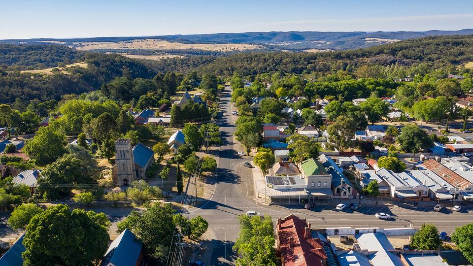 A town with a prominent church, a main street, and surrounding hills.