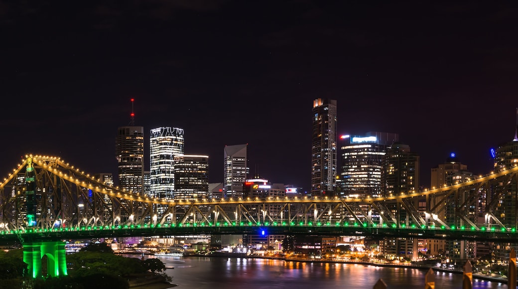 Panoramic view of Story bridge in yellow and green light at nigh time in Brisbane Australia