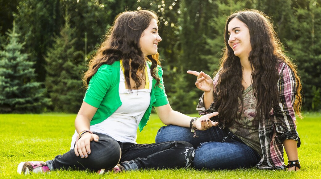 Two Sisters Talking Outdoors In Autumn; Sherwood Park, Alberta, Canada