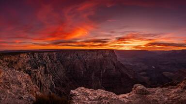 Cañón con formaciones rocosas estratificadas y un cielo al atardecer.
