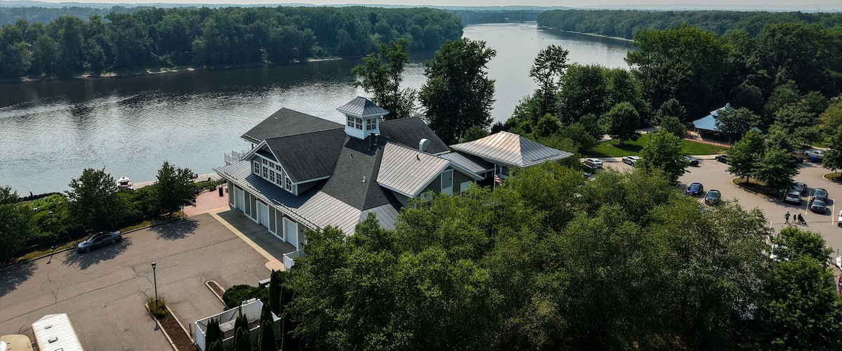 A lakeside property with a large house, a dock, and a parking area.