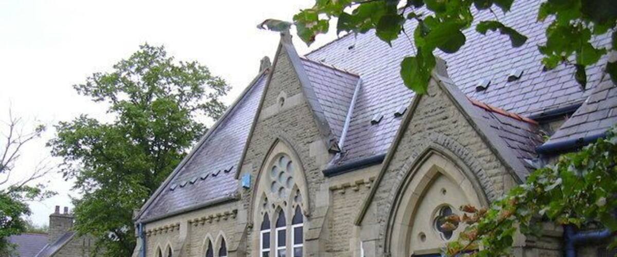 Un edificio de piedra con una puerta azul y ventanas de arco apuntado.