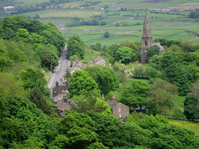 Holcombe Village. The village of Holcombe is in the middle of all the trees with 330268 on the right. The village occupies a picturesque position on the slopes of Holcombe Hill. The buildings in the area are predominantly made up of stone cottages a public house, a restaurant, church and primary school. At one time the village also boasted a shop, post office, and a regular bus service linking it to Holcombe Brook, a neighbouring village in the valley bottom one mile to the south. The main road to the left is Helmshore Road with the sign on wall of 444148 in the foreground.