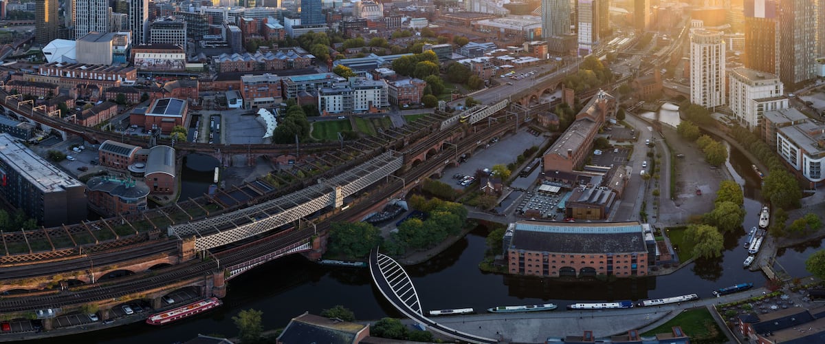 A cityscape with a prominent bridge, a river, and a stadium.