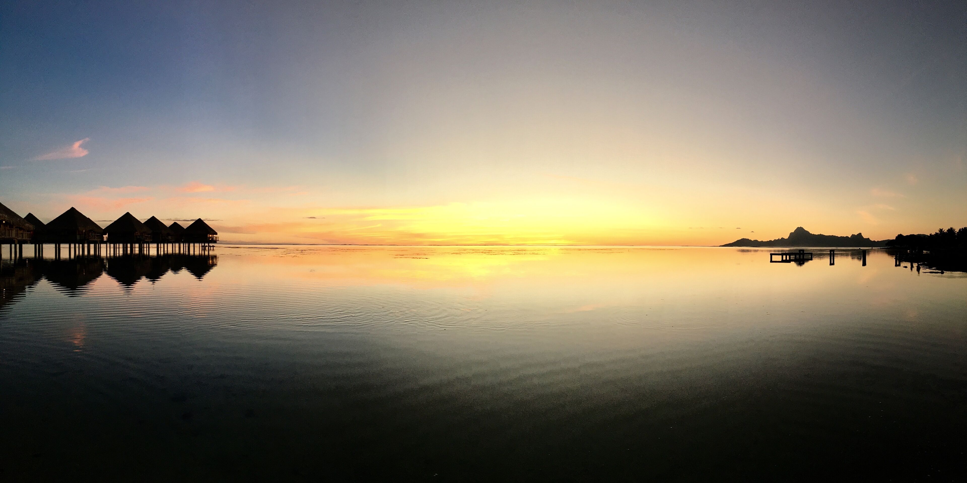 Beautiful view on Moorea and the overwater bungalows of a luxury resort during sunset at the beach of Punaauia