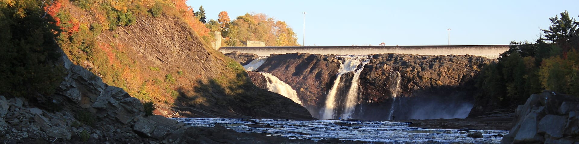 Waterfalls and river in autumn. Public park and Power plant