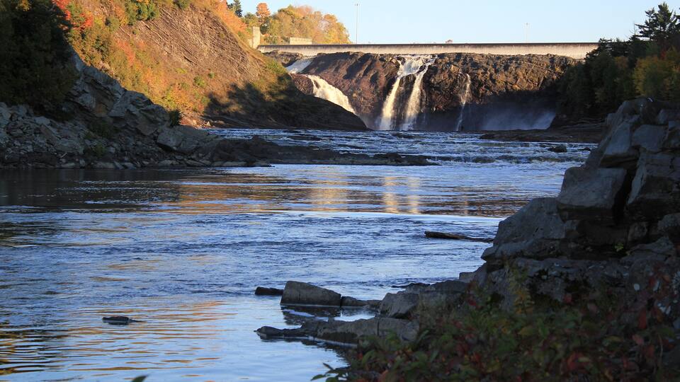 Waterfalls and river in autumn. Public park and Power plant