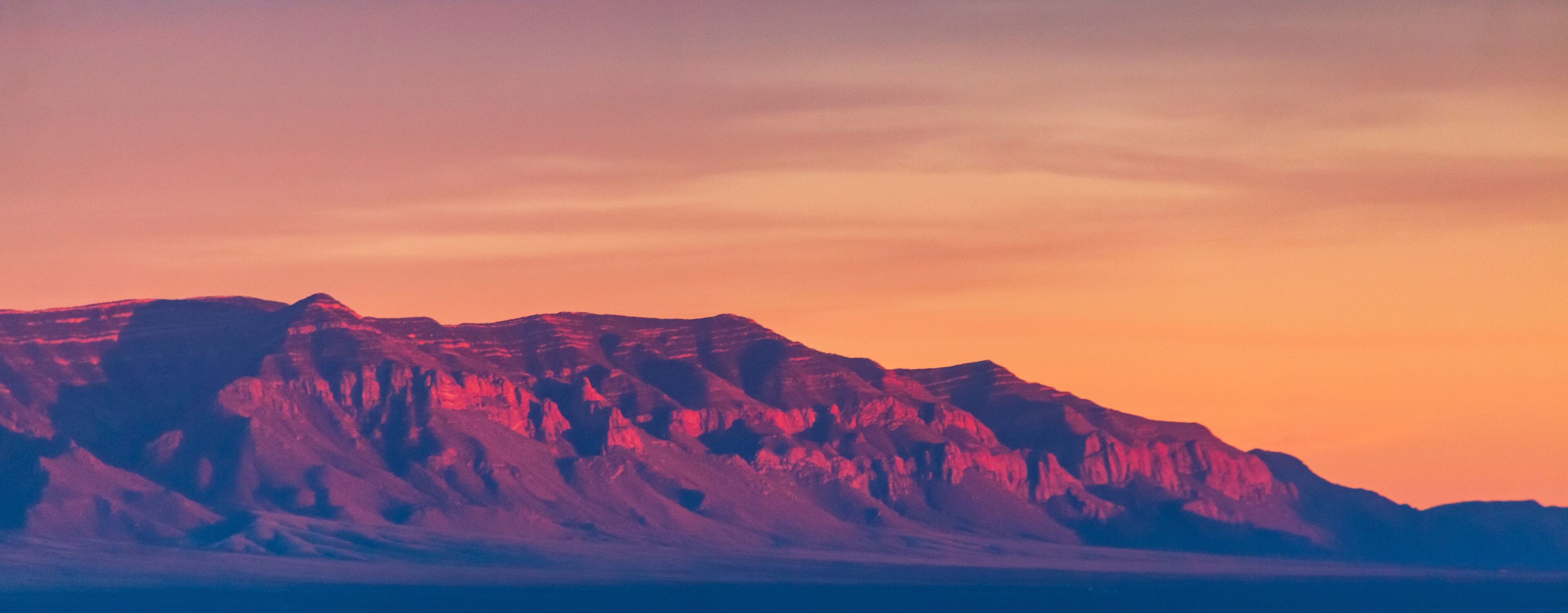 A mountain range with a sunset sky.