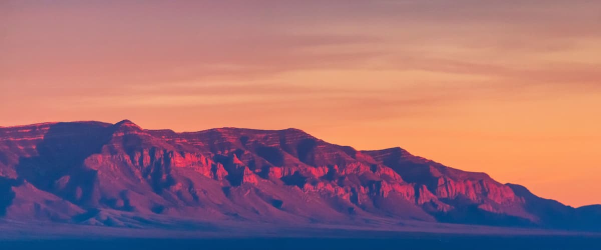A mountain range with a sunset sky.