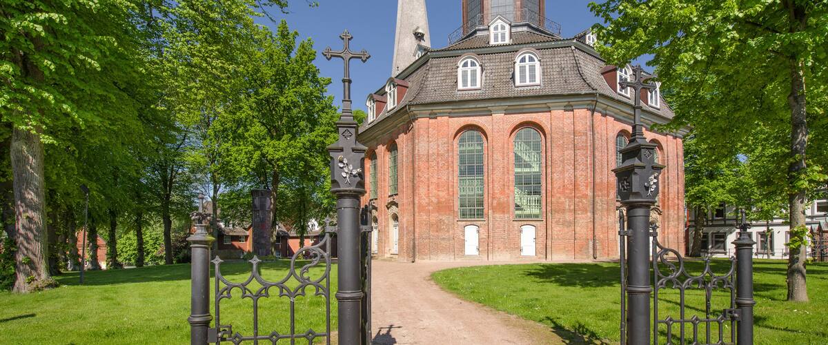 A church with a tall steeple and a brick facade.