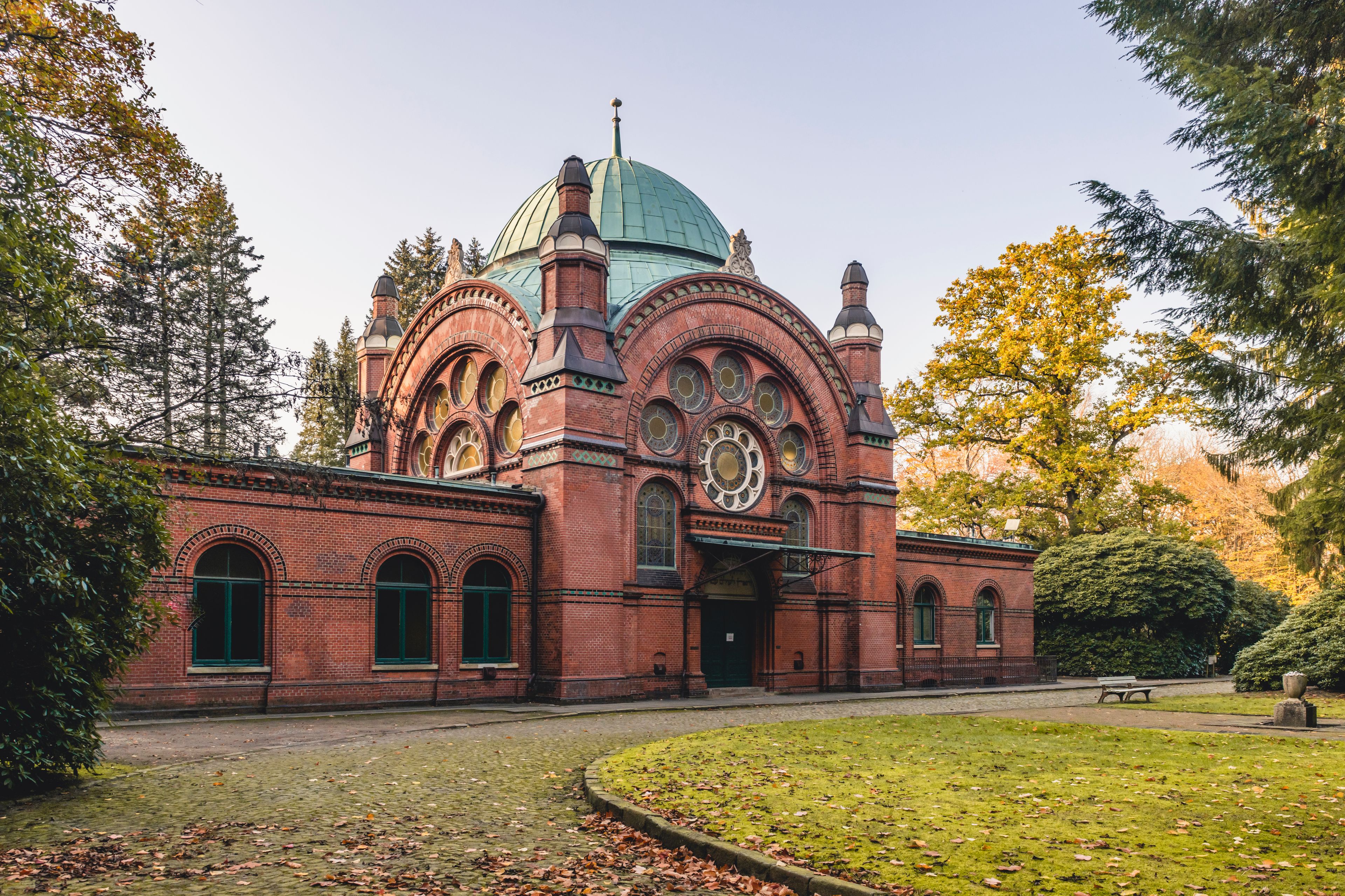 A historic brick building with a green dome and arched windows.