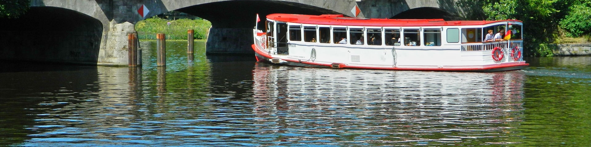 Das Alsterschiff Sielbek auf dem Langen Zug vor der Langenzugbrücke. Auf dem Langen Zug verläuft die Grenze zwischen Hamburg-Uhlenhorst und Hamburg-Winterhude.
