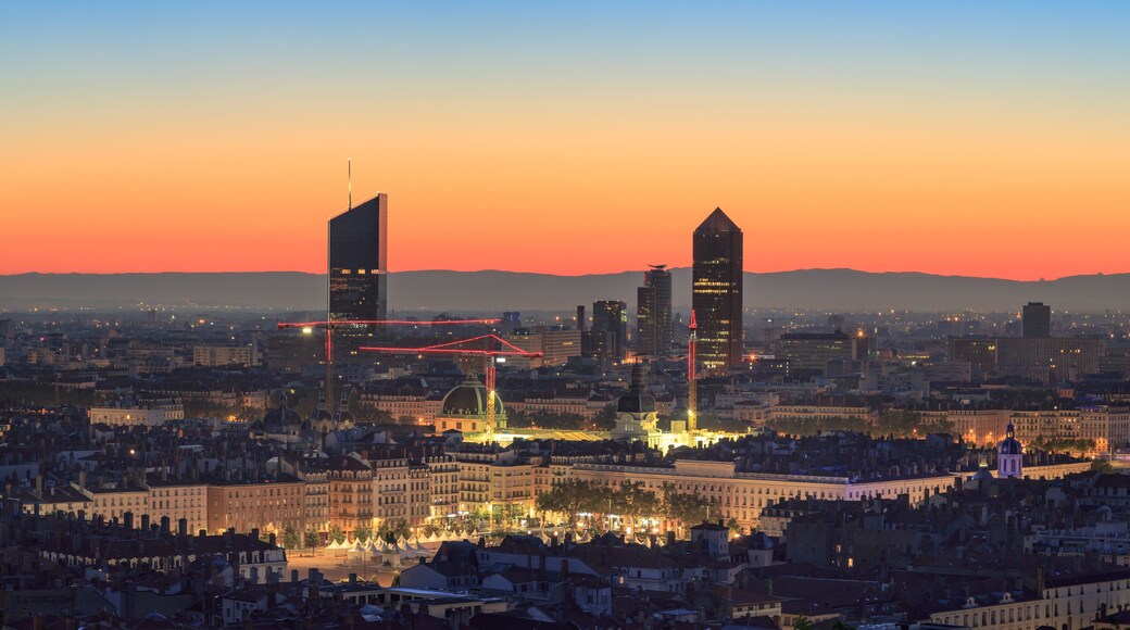 Place Bellecour and the towers of Part-Dieu in the city of Lyon, France, at dawn.