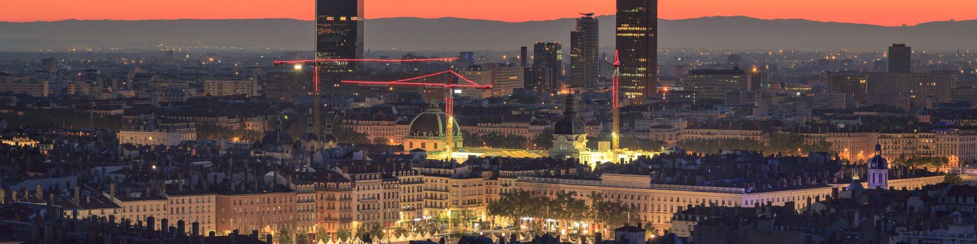 Place Bellecour and the towers of Part-Dieu in the city of Lyon, France, at dawn.