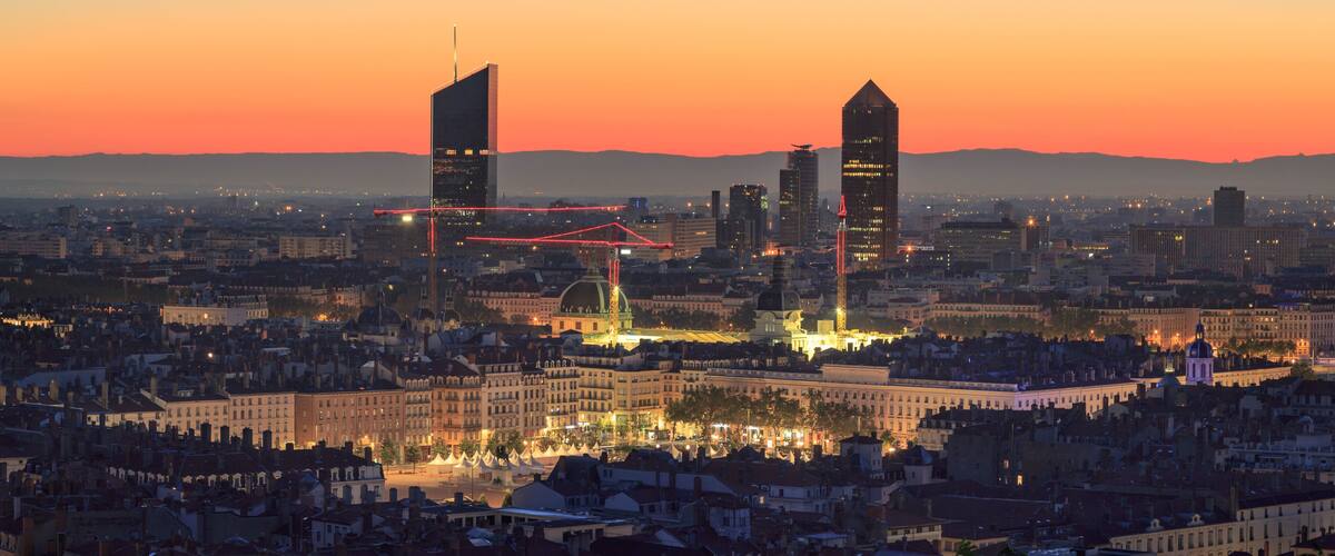 A cityscape at dusk with prominent skyscrapers, a historic building, and a network of illuminated red lines.