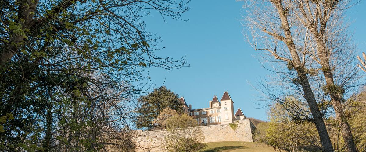 A historic building with a stone wall and a hill.