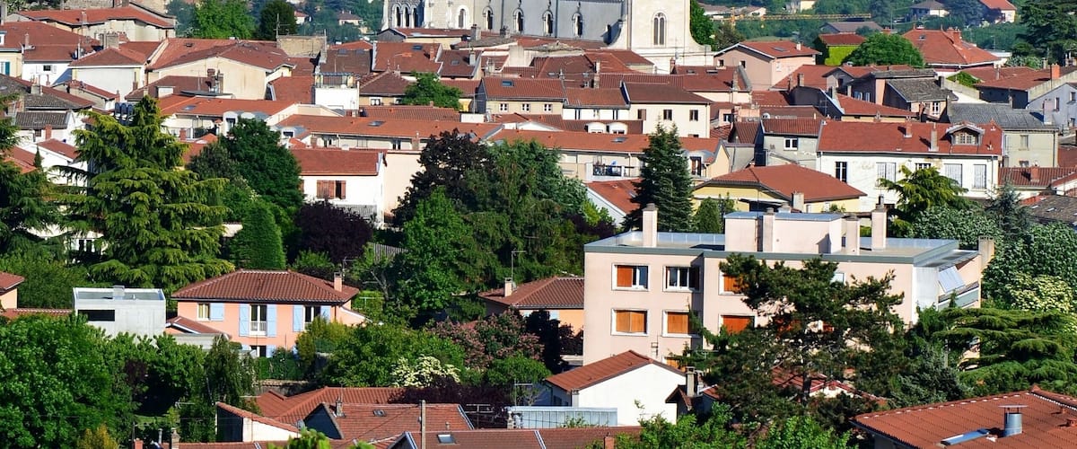 A town with a prominent church tower, surrounded by residential buildings and greenery.
