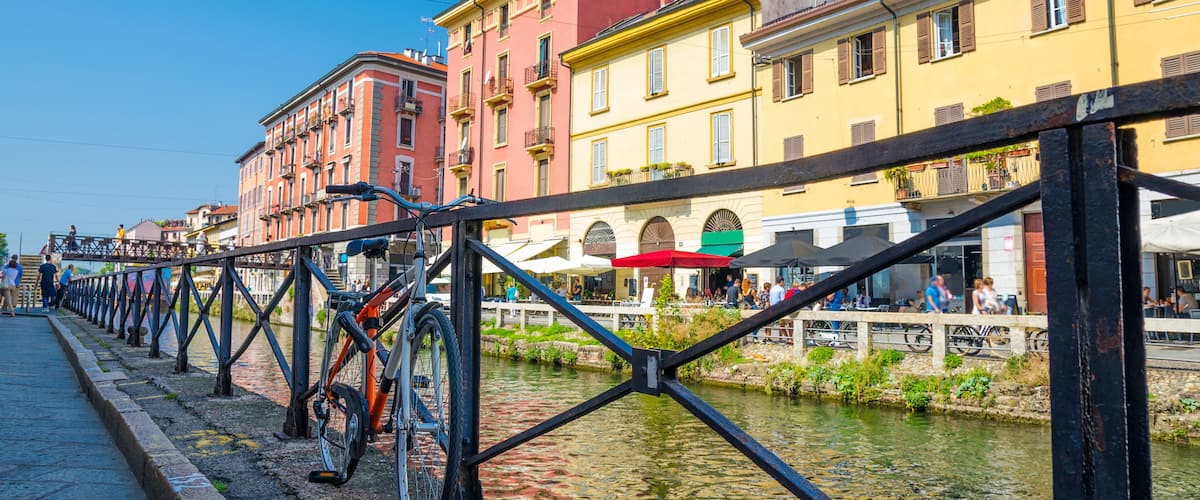 A canal with colorful buildings and a bicycle.