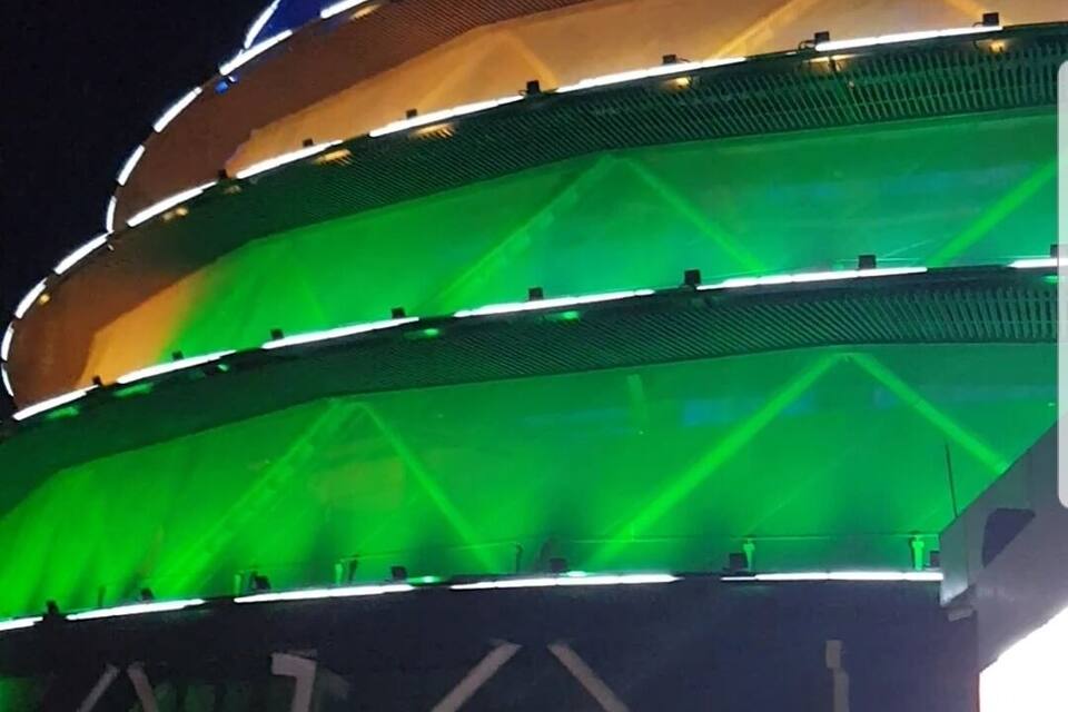 Un vaste stade à plusieurs niveaux, doté d’un toit incurvé et illuminé de lumières colorées.
