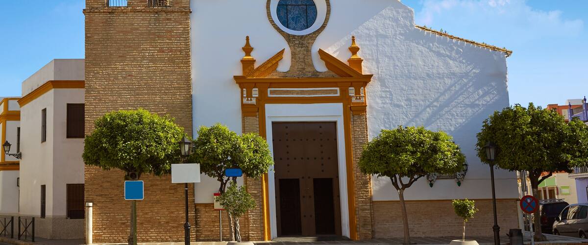 A church with a bell tower and a large circular window.