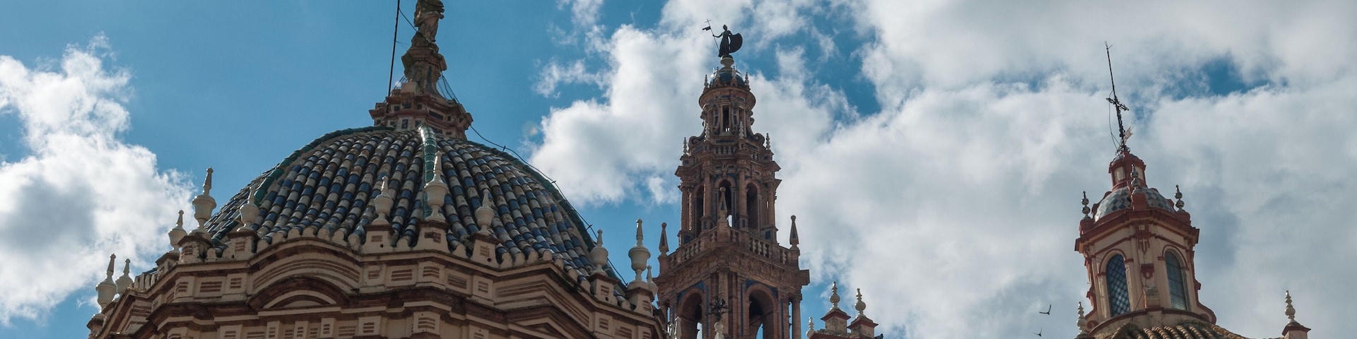 A historic building with a large dome and bell tower under a partly cloudy sky.