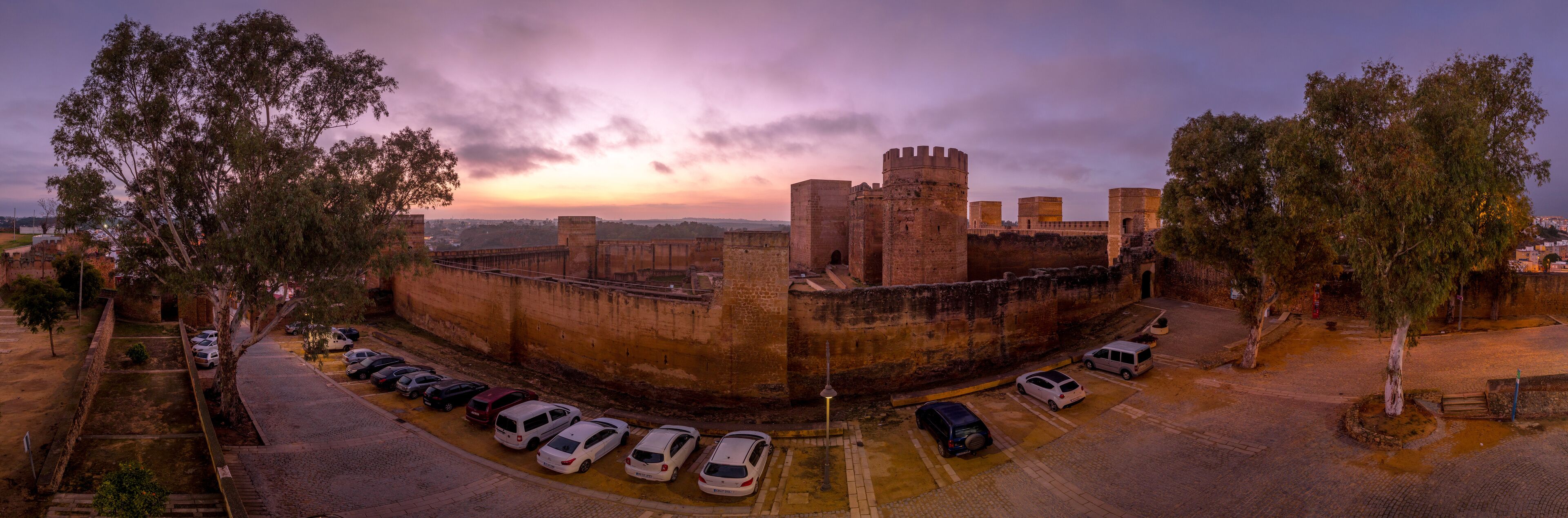 Alcalá de Guadaíra Castle: A Study in Moorish &amp; Gothic Design, square towers, battlements sunset sky