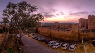 Alcalá de Guadaíra Castle: A Study in Moorish & Gothic Design, square towers, battlements sunset sky