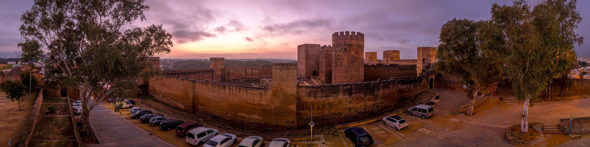 Alcalá de Guadaíra Castle: A Study in Moorish & Gothic Design, square towers, battlements sunset sky