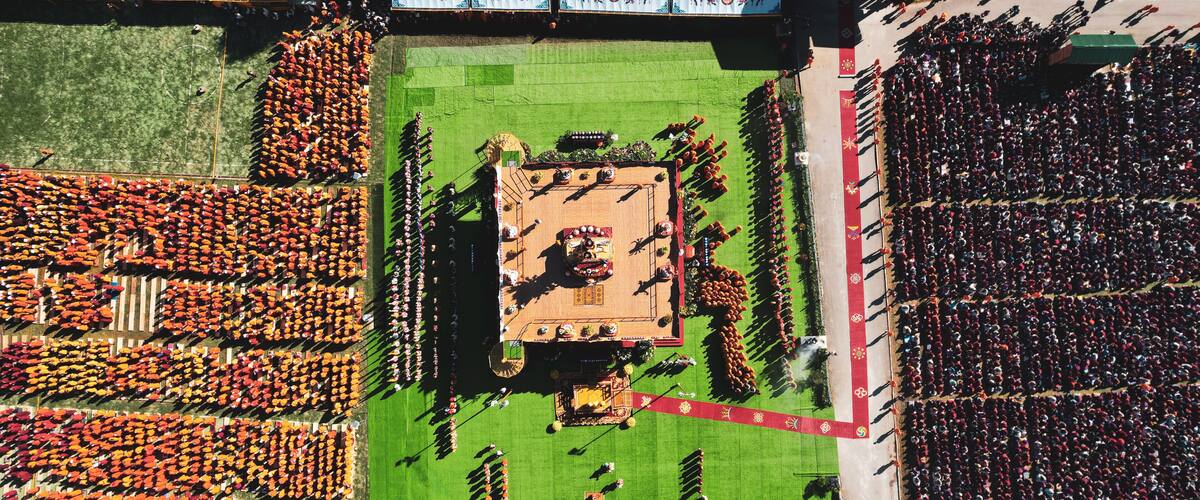 An aerial view of a stadium with a central square, surrounded by organized seating areas.