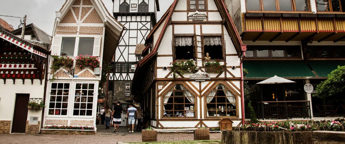 A traditional European town square with timber-framed buildings, a pub, and cobblestone streets.
