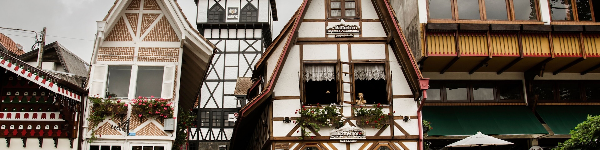 A traditional European town square with timber-framed buildings, a pub, and cobblestone streets.