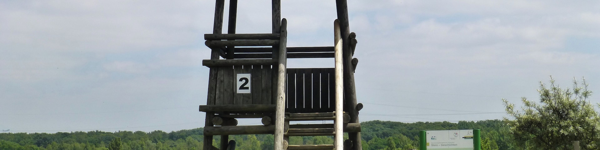 A wooden observation tower with a roof, labeled '2', surrounded by a fence and greenery.