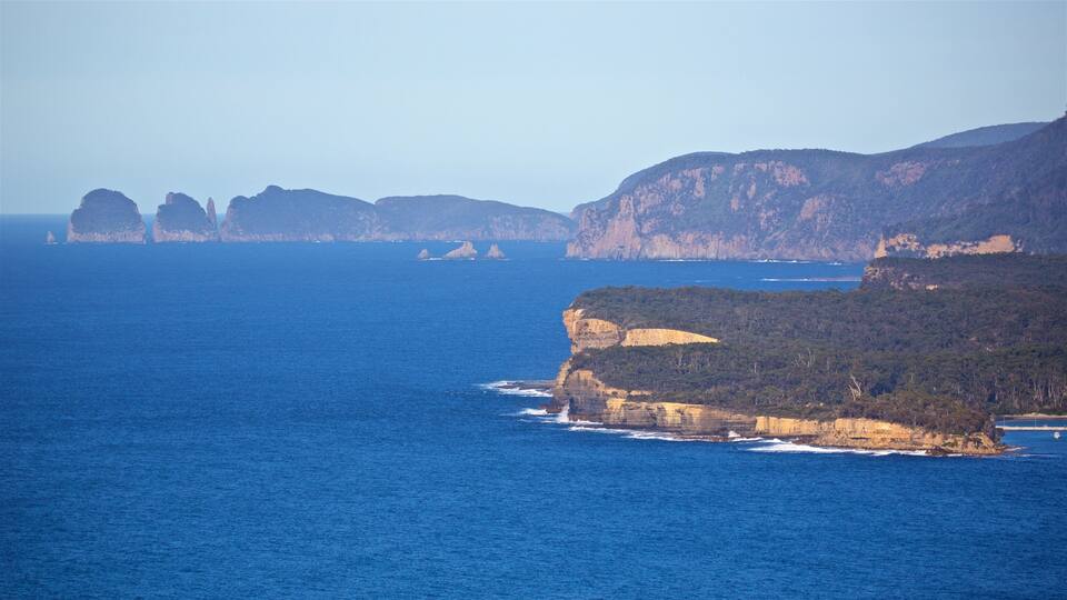 A coastal landscape with cliffs and a clear blue sea.