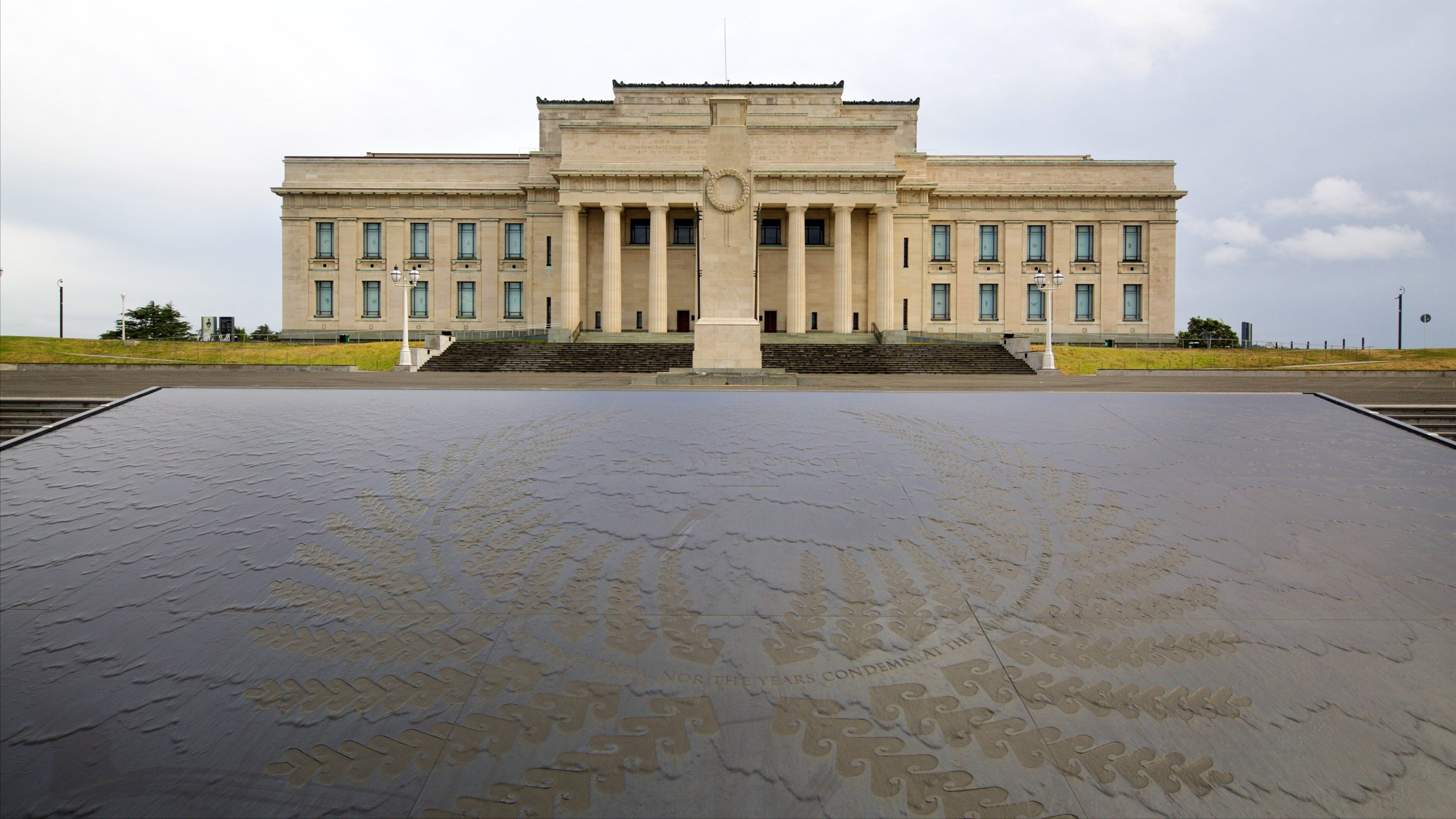 Un grand bâtiment de style néoclassique, doté d’une entrée centrale flanquée de colonnes.